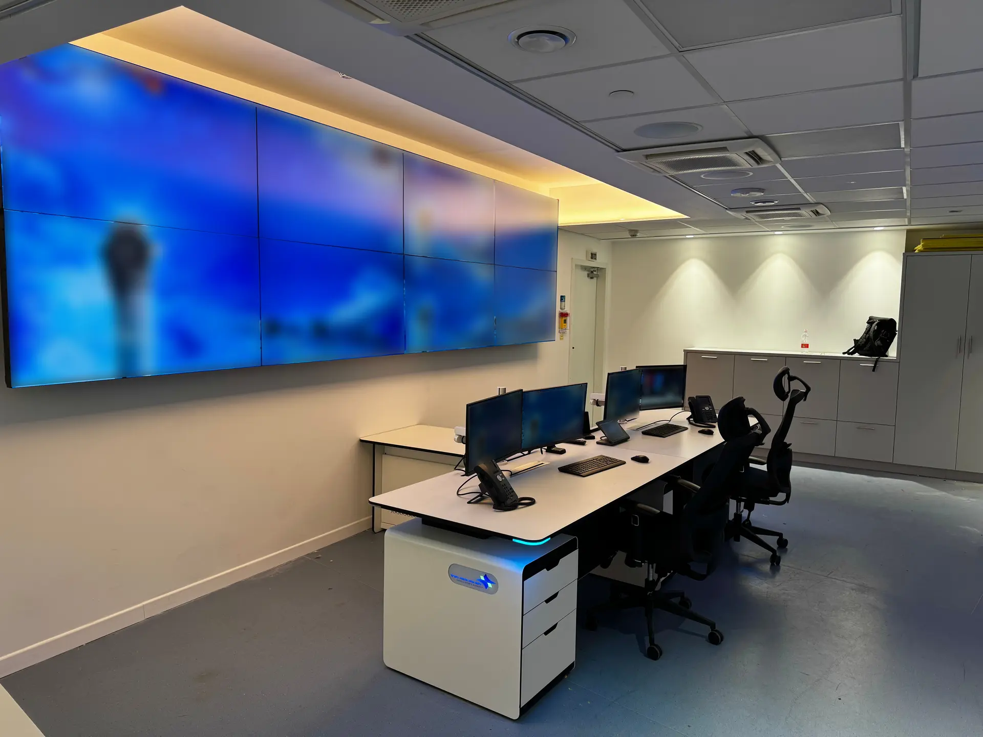 Angled view of the workstations, video wall and storage units in the operations room
