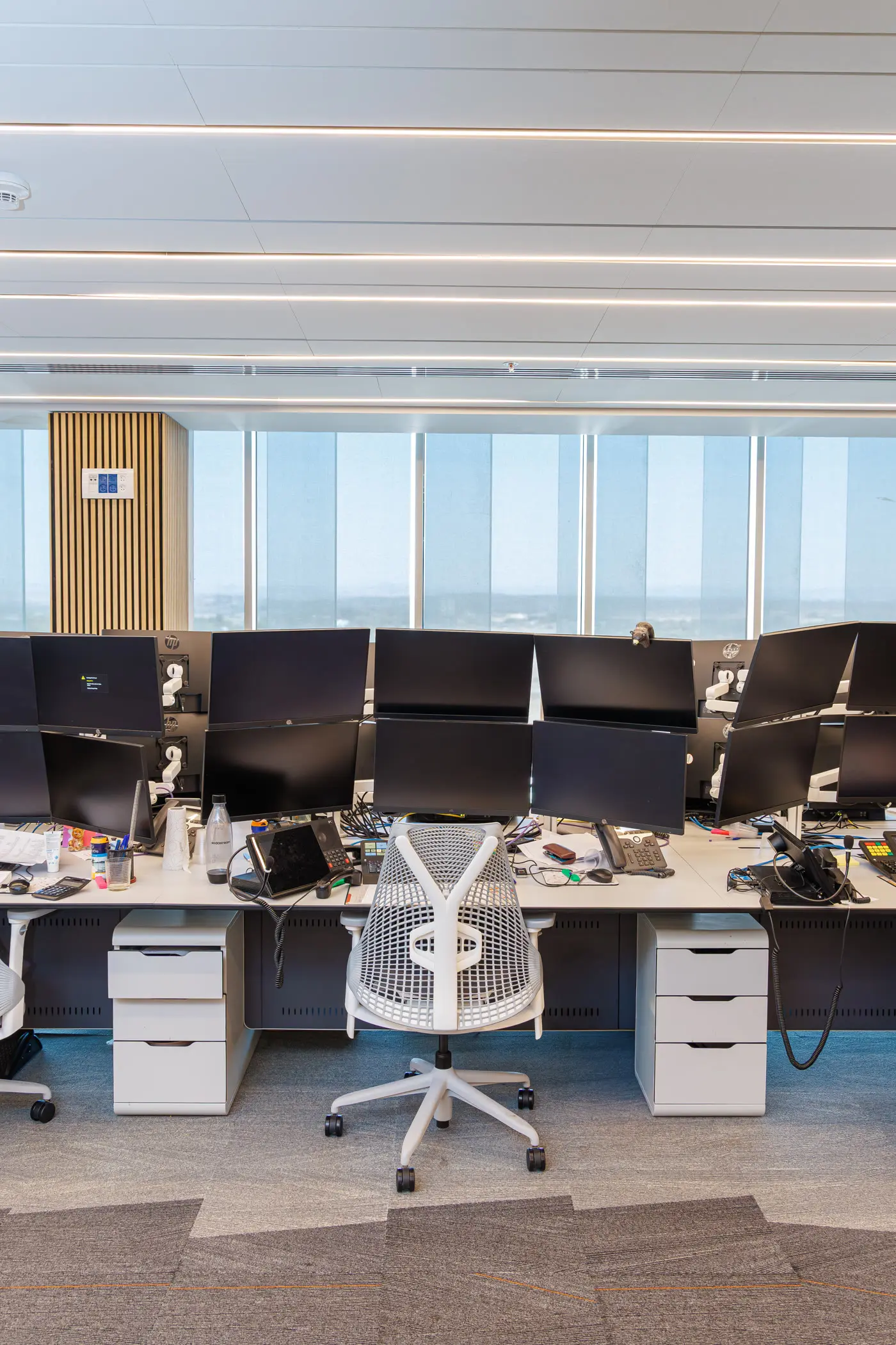 Multi-monitor trading workstation facing the room windows